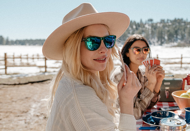 Sunglasses with glossy green fronts, wooden arms and polarized green lenses, model